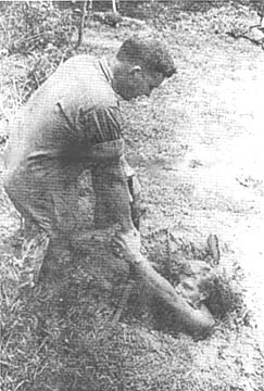 1Lt. Albert Are helps PFC Steve Crum out of tunnel